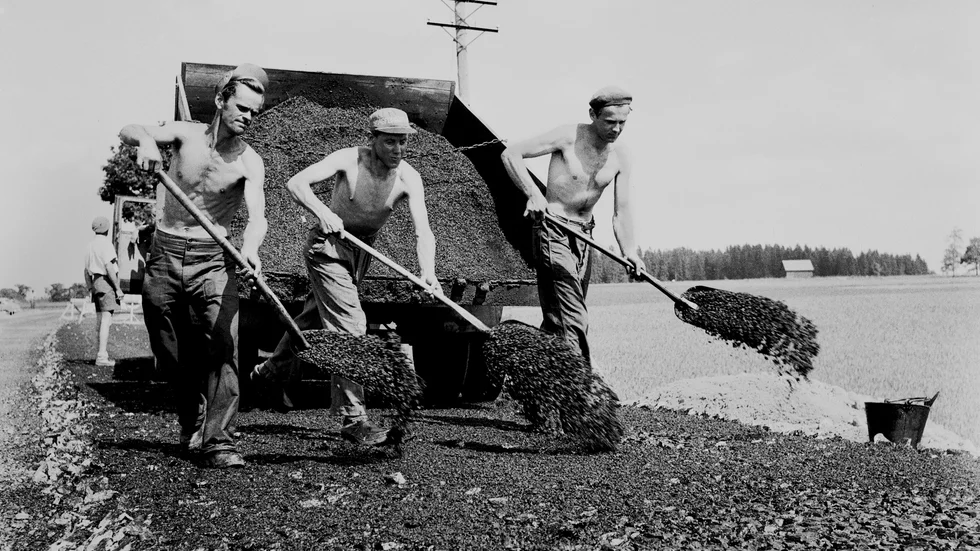 7 juli 1955. Asfaltering av Riksettan mellan Mantorp och Sya. ”Arbetsslavar i hettan” skriver Corren om vägjobbarna Rune Nero och Folke Rydell från Skänninge och Gunnar Windolf från Mjölby.