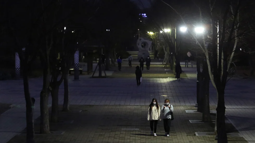 Två personer med munskydd på promenad längs en gata i Goyang, nordväst om Seoul, under söndagen.