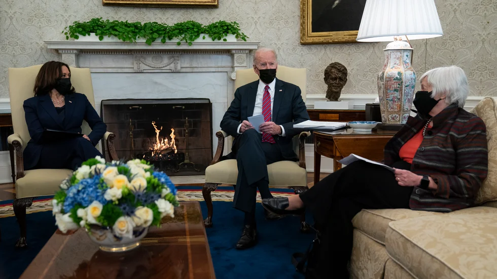 Brasan sprakar i bakgrunden när USA:s president Joe Biden och vicepresident Kamala Harris träffar finansminister Janet Yellen. Arkivbild.