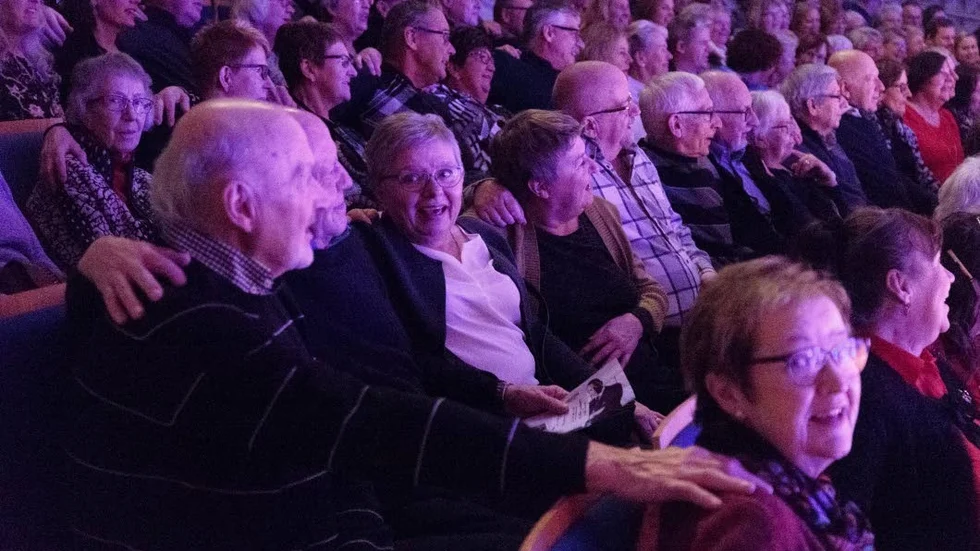 Glada miner i en välfylld konsertsal.