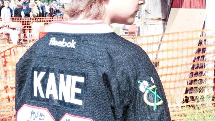 Melvin Hällström visar glatt upp sin tröja fylld med autografer.
