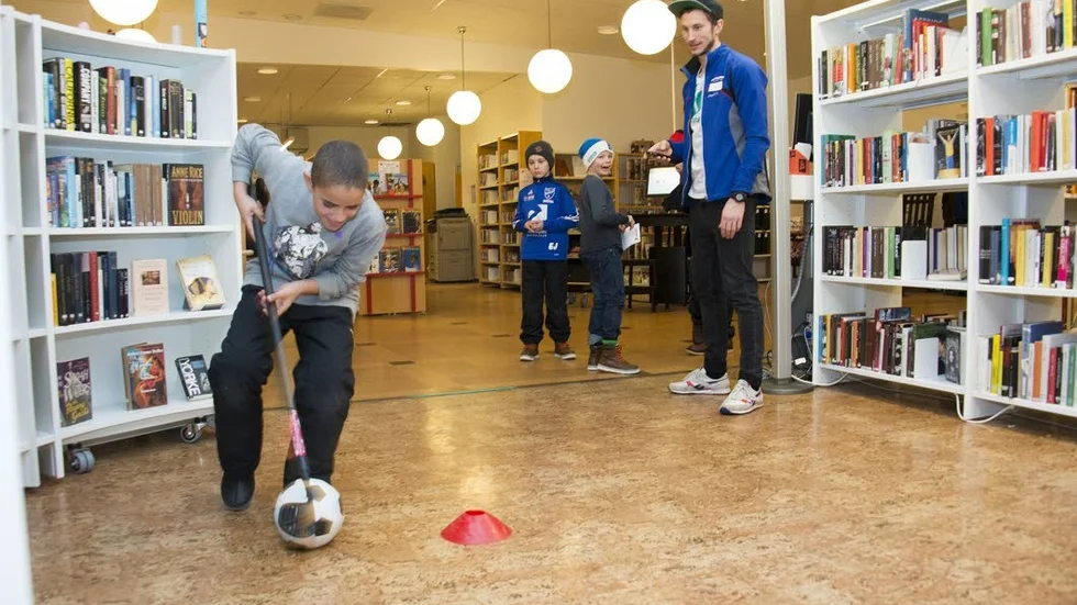 Biblioteksaktivitet. Abdulkarim Ali ger järnet på innebandy­slalombanan. Eddie Juliusson och Frans Lindström väntar på sin tur och Hannes Boström ­sköter tidtagningen.