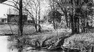 Den här vackra vårbilden visar Ljura bäck ringlande runt Ljura gård, grannskapsgård till Risängen. (Ur Stadsarkivets samlingar.)