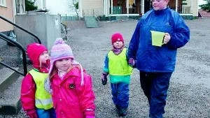 Dagmamma Carina Boström hämtar vatten vid tappen på skolan tillsammans med några barn.