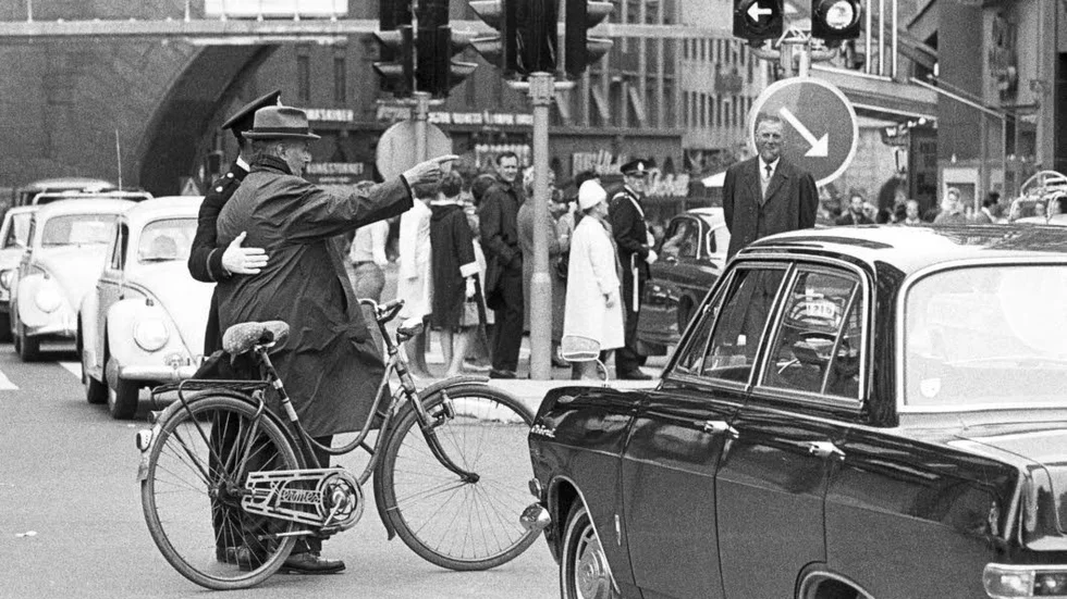 En polisman hjälper en äldre man till rätta i korsningen Sveavägen-Kungsgatan dagen H den 3 september 1967.