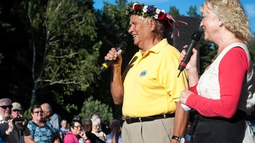 Inför sin sista kväll som allsångsledare fick Hasse Crantz fick en blomsterkrans av Ewa Persson.