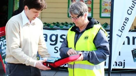 Coop Konsums butiksföreståndare Nic Söderqvist i Krokek  tar emot hjärtstartaren av Lions Kolmårdens president Solveig Almkvist.