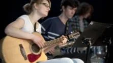 Josefine Davidsson spelar akustisk gitarr i kompbandet.