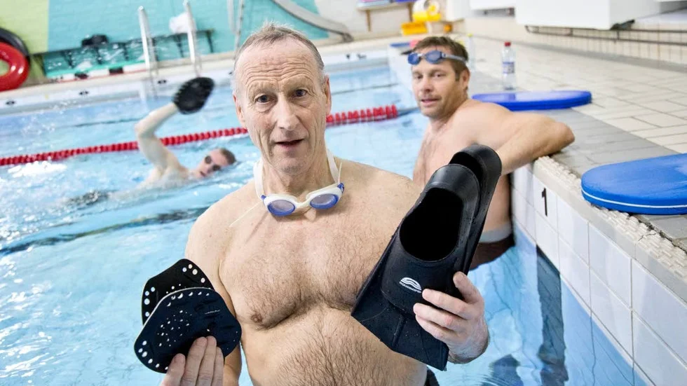 Hans Byström visar redskap som underlättar, paddlar och simfötter. Men det är jobbigt ändå. "Det är fruktansvärt jobbigt", säger han. Bakom honom pustar Mats Åkerlund ut innan det är dags för nästa vända.