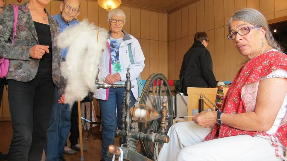 Christina Kolmert demonstrerade spinnrockens trådfabricerande konst för, från vänster, Gunvor Bergeman, Kurt och Anni Svensson.