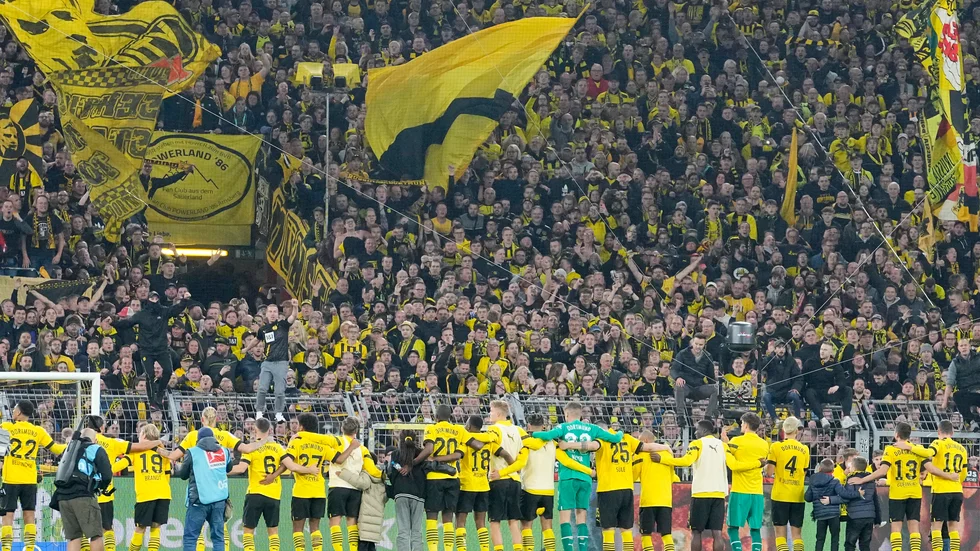 Dortmunds spelare firar poängen mot Bayern München med sina supportrar.