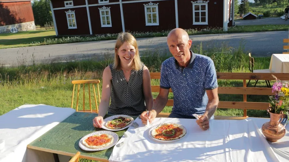 Rolf och Emma Wallin njuter av pizza i solen.