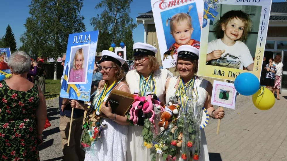 Julia Norström Barsk, Emilia Gregersen och Julia Emilsson behängda med presenter och blommor. "Bästa dagen i livet" säger de.