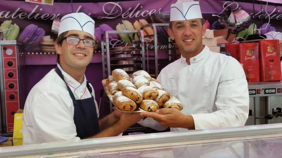 Andrian Menar och Ahmed Abada poserar glatt med sina nybakade croissanter