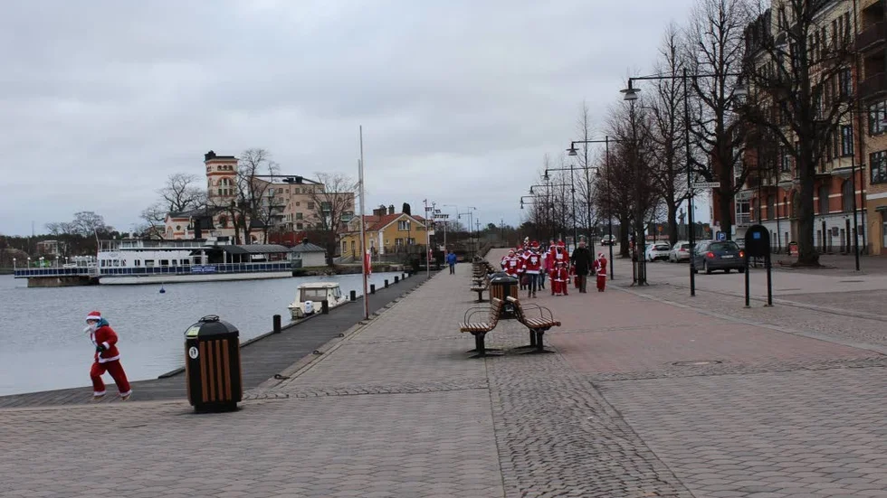 Tomteparad. Här kommer tomteparaden genom Västervik. En av nissarna kilar i förväg.