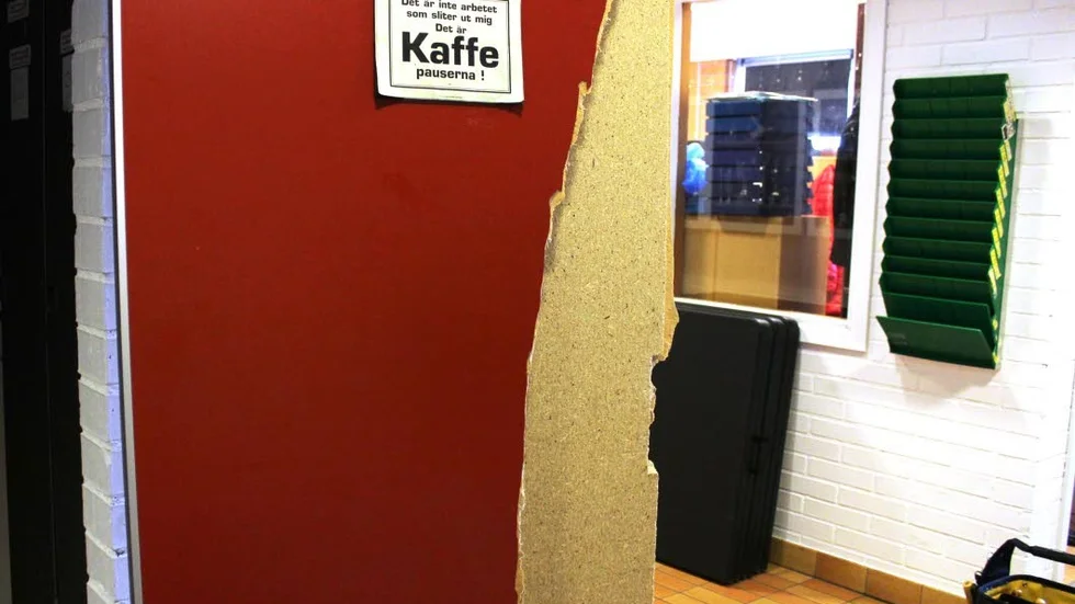 Sönder. Dörren har forcerats på ett kraftfullt sätt, den var helt sönderslagen.