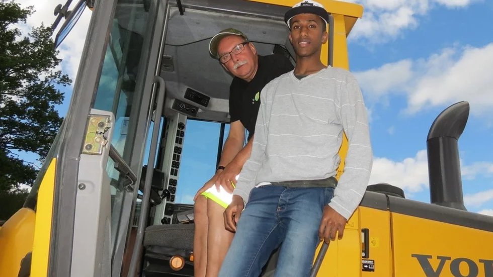 Ibrahim Mohamed 16 år från Somalia provar på att köra traktor tillsammans med Gamlebygymnasiets Peter Gustafsson.
