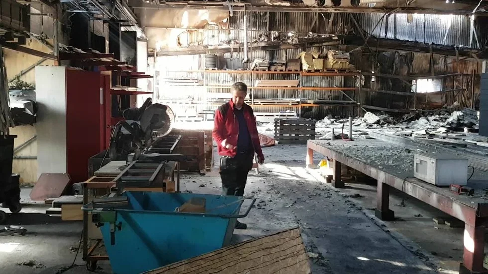 Mattias Liljedahl på Sångsholm Prefab i de delvis eldhärjade lokalerna. Värmen från branden intill har smällt alla elkablar. Men kontoret på entresolvåningen är intakt.