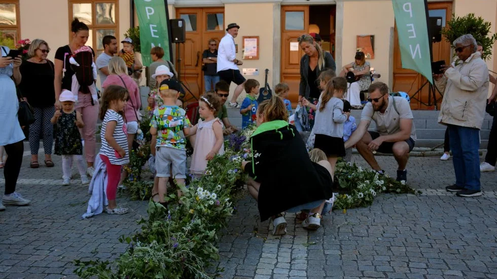 DEKORERA. Många barn hjälper till att dekorera midsommarstången innan det är dags för dans.