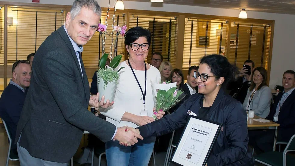 Kommunalrådet  Kåre Friberg och Lena Åberg från bildningsförvaltningen tar emot blommor och diplom.