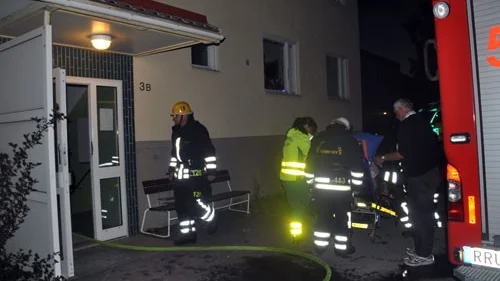 Den rökskadade mannen förs på bår bort till ambulansen.