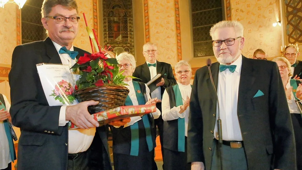 Stig-Erik Eriksson överlämnade en stor blomma och ett paket till Gösta Larsson. Foto: Roelof Stroetinga