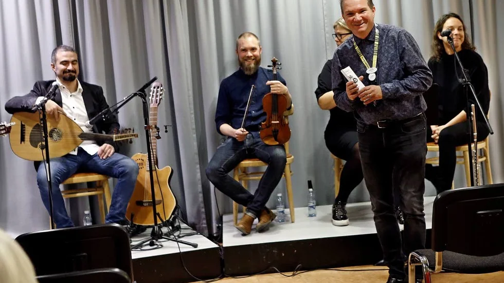 Tonny Henriksson presenterar Motala världsmusiksamfund innan bandets första publika spelning på Motala bibliotek.