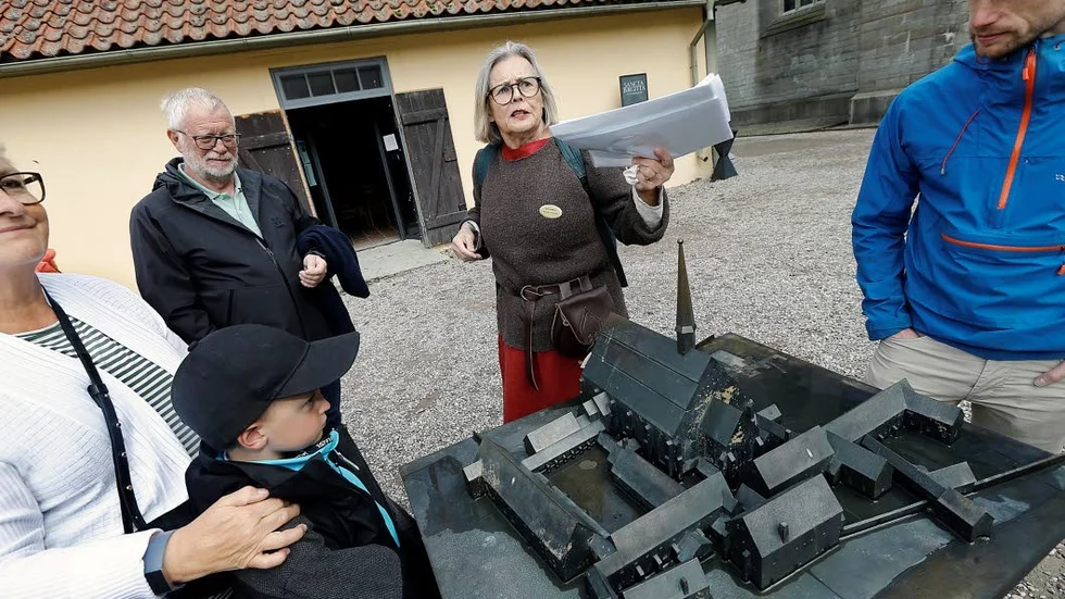 Guiden Maria Junaeus och gruppen framför en modell över klosterområdet.
