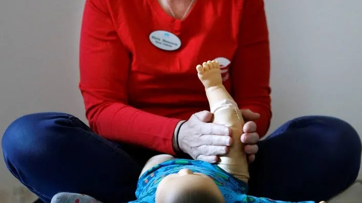 Maria Meszaros instruerar och visar med hjälp av en docka.