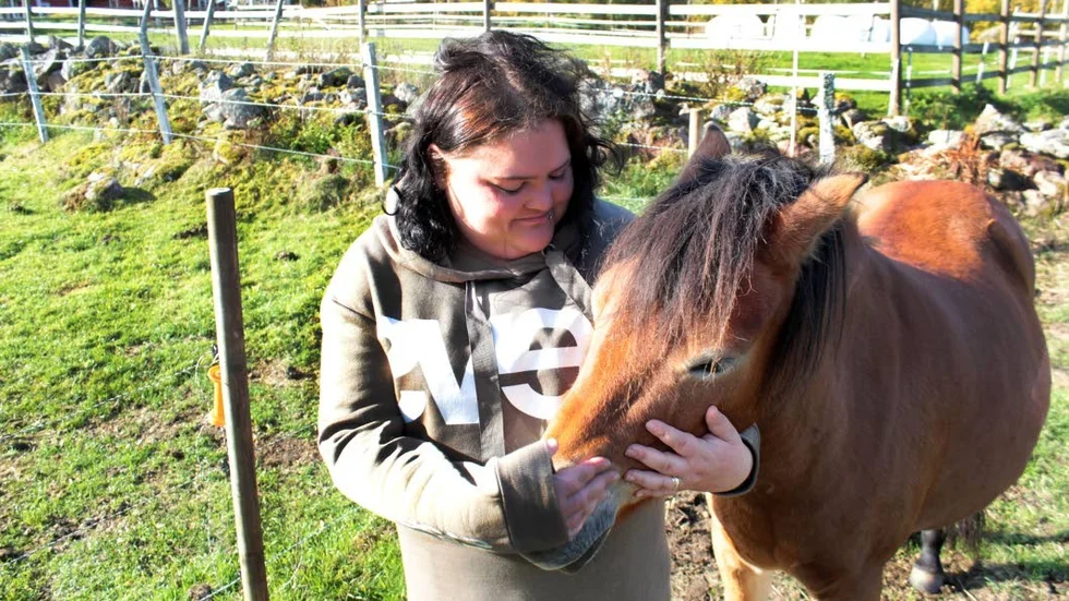 Anna håller om ett av de två lånade stona som man ska försöka para med sina egna hingstar