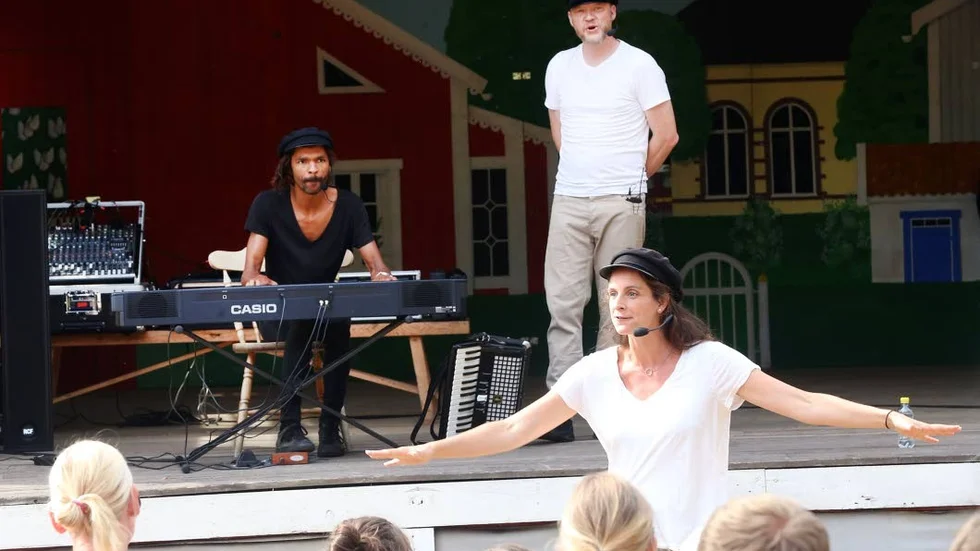 Tre skådespelare, varav en bakom pianot och två aktörer framför en musikteater där publiken får vara med.