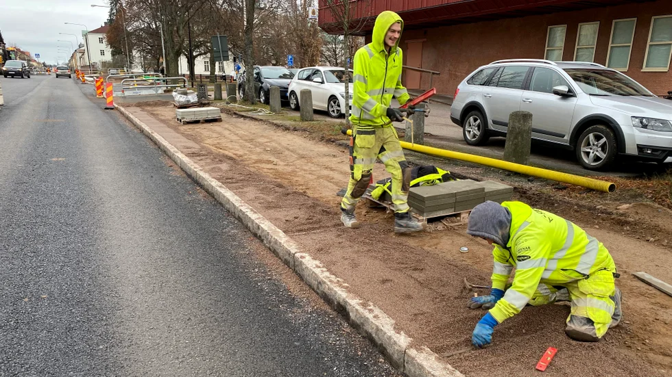 Philip Åhlander och Sai Mahdavi lägger ner rör som de med vattenpass korrigerar för att de ska hamna i rätt höjd. Därefter kan gruset jämnas till så att markstenarnan kan komma på plats.