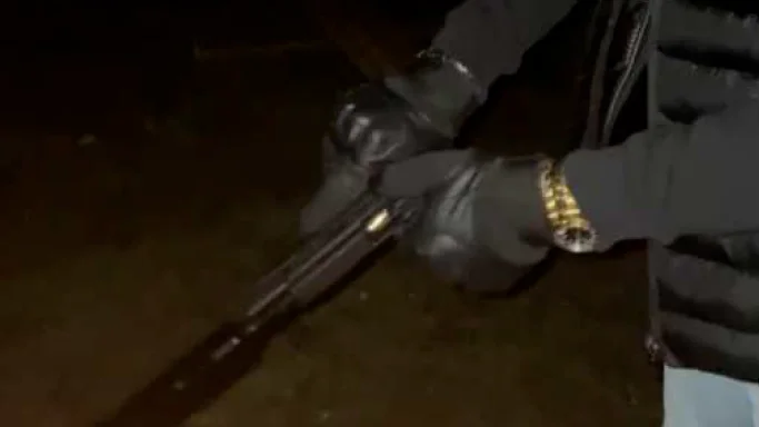En okänd man mantlar en pistol med ljuddämpare. Någon sekund senare avfyras vapnet. Flera detaljer i den här bilden kopplas nu till den nu dömda mannen.