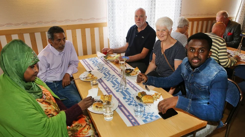 Svenskar och människor från Somalia äter utländsk mat tillsammans, en härlig kombination.