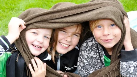 Elin Sjösten, Filippa Evert och Wilma Jansson håller värmen inlindade i en filt.