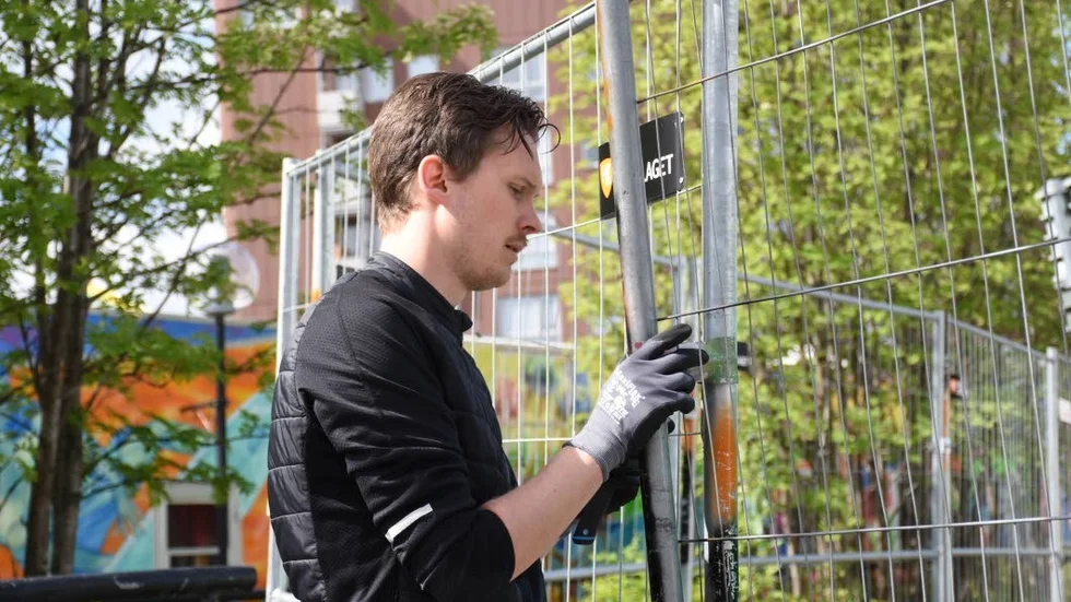 Anton Karlström, städsamordnare, lagar staketet som ramar in festivalområdet.