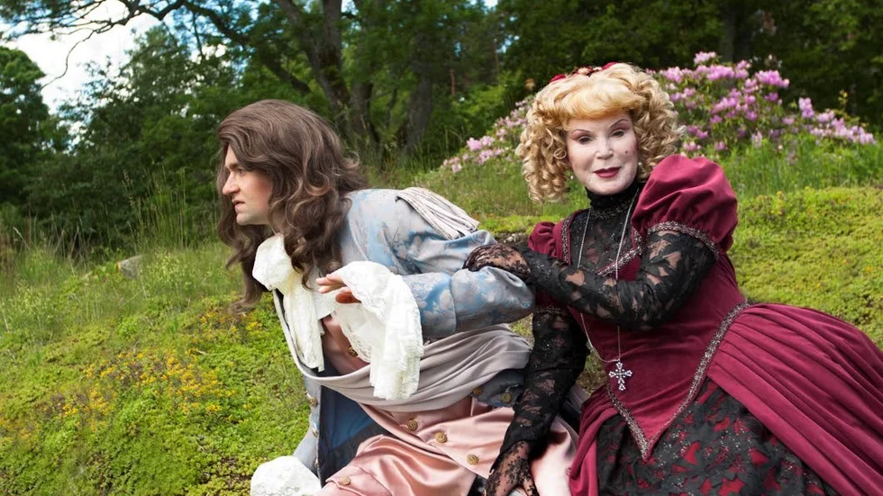 Friluftsteater. Madame Tartuffe (Anne Kulle) och Damis (Thomas Eriksson) i det gröna. Damis försöker smita från den pilske Tartuffe.