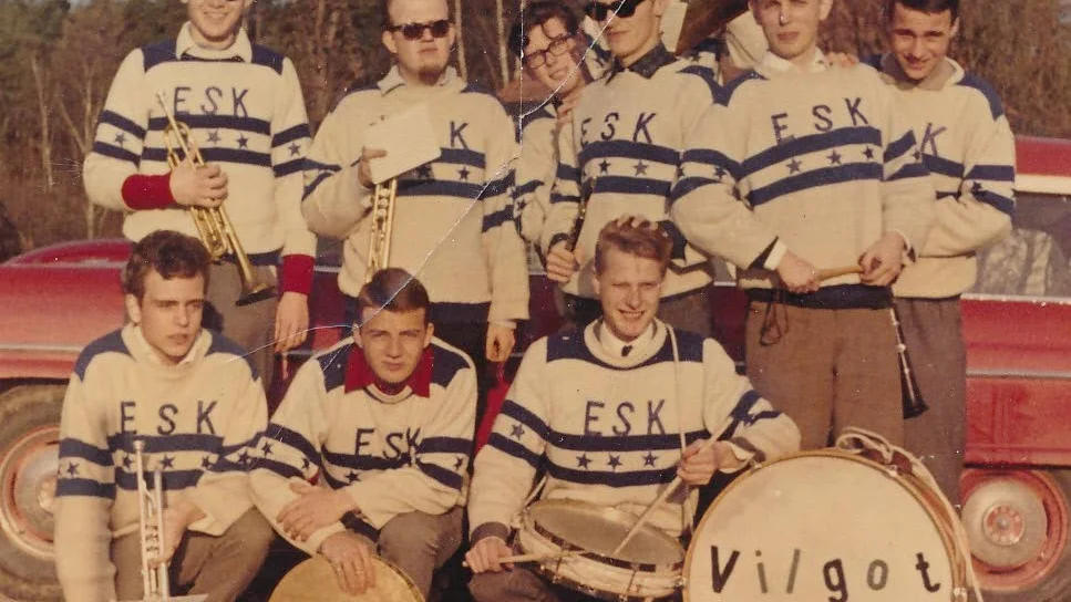 Studentorkester uppträdde alltid i ESK-tröjor. Från vänster: Tholeif Johansson trumpet, Esse Almqvist trumpet, Martin (tittar fram) bastuba, Nils Steen flöjt, Jan-Åke ”Pinnen” Gestblom klarinett (överst), Tomas Svegrell bastrumma och Bengt Högberg klarinett. Knästående: Fritz ”Fritte” Eriksson trumpet. Peter Wilander cymbaler och Sten "Stena" Pettersson virveltrumma och klarinett.