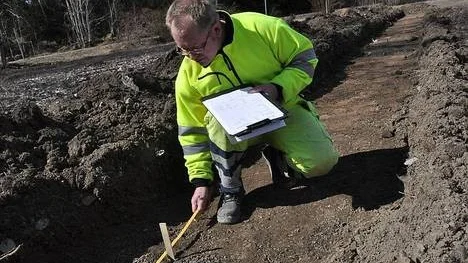 Holback registrerar fynd i ett av flera utredningsschakt som grävs över den planerade tomtmarken.