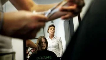 Frisören Ann-Katrin Kleinau övervakar när eleven Therse Entersten klipper Sara Magnusson.