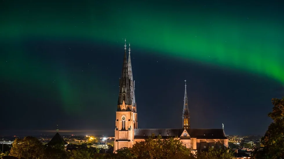 Norrskenet ringlar sig över Domkyrkan vid midnatt. Fotograferat från Gunillaklockan.