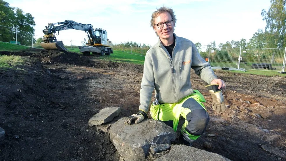 Husgrund. Arkeolog Mikael Bertheau vid en av de delar av husgrunder som blottlagts i samband med marksaneringen.