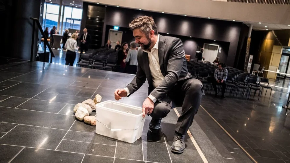 Producenten av slutnumret Björn Pettersson Thuri samlar ihop stenarna, árran, efter uppträdandet. "Symboliken med eldstaden går tillbaka till viljan att detta ska bli Kirunas vardagsrum", säger han.