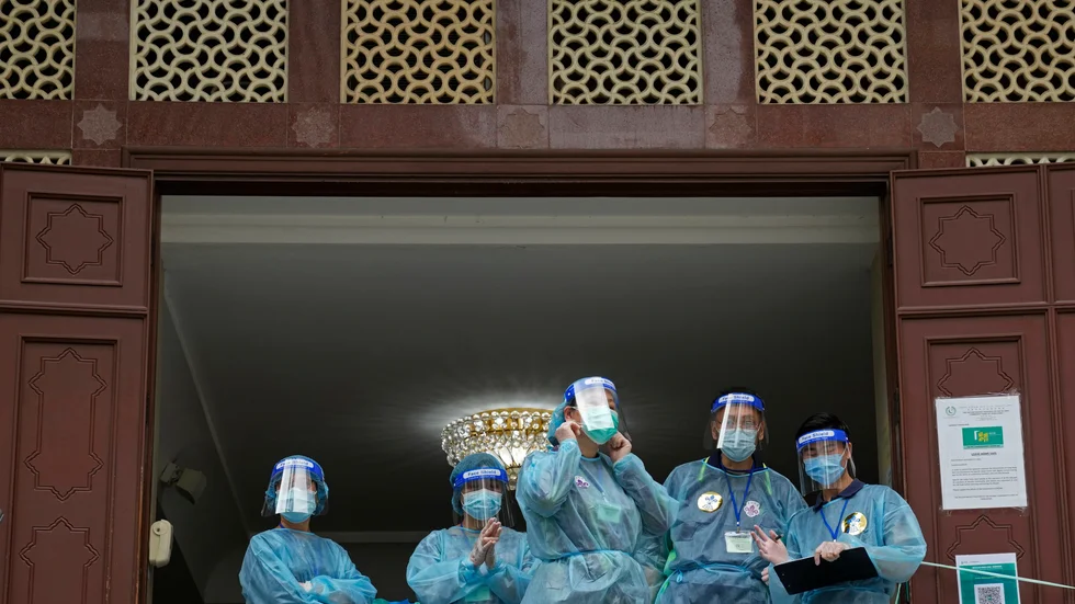 Vårdanställda i skyddsutrustning redo att vaccinera i Hongkong.