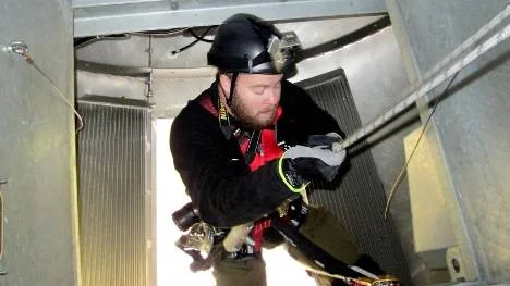 Utan att tveka låter sig Andreas Johansson, Swevind, vinschas ner från 108 meters höjd till marken.
