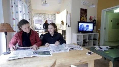 Emmy Carlsson och Sanna Andersson i elevboendets allrum med tillhörande kök. Eftersom de fått lite tid över mellan morgonens stalltjänst och förmiddagens ridlektion tänker de äta en extra frukost. Men först hittade de något om hästar att läsa i tidningen.
