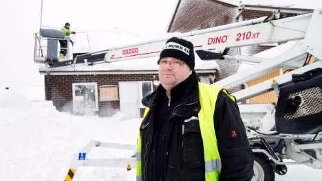 Med hjälp av en skylift kan Daniel Vesterlund smidigt skotta av taket medan Tomas Hallin står på marken och övervakar skottningen.