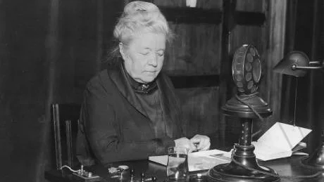 SOM EN DROTTNING. Våren 1889 klippte Selma Lagerlöf av sig håret och fann sin stil. Två år senare debuterade hon med Gösta Berlings saga. Här talar hon i radio 1925.
