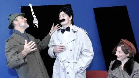 Bekymrad doktor. Doktor Perpelaine (Johan Ahlsén) och dennes fru (Sonja Bertogna) har inte nog med lovord om den vackra byn Saint-Maurice. Doktor Knock (Kristian Pedersen) är mest bekymrad över byns för friska invånare.
