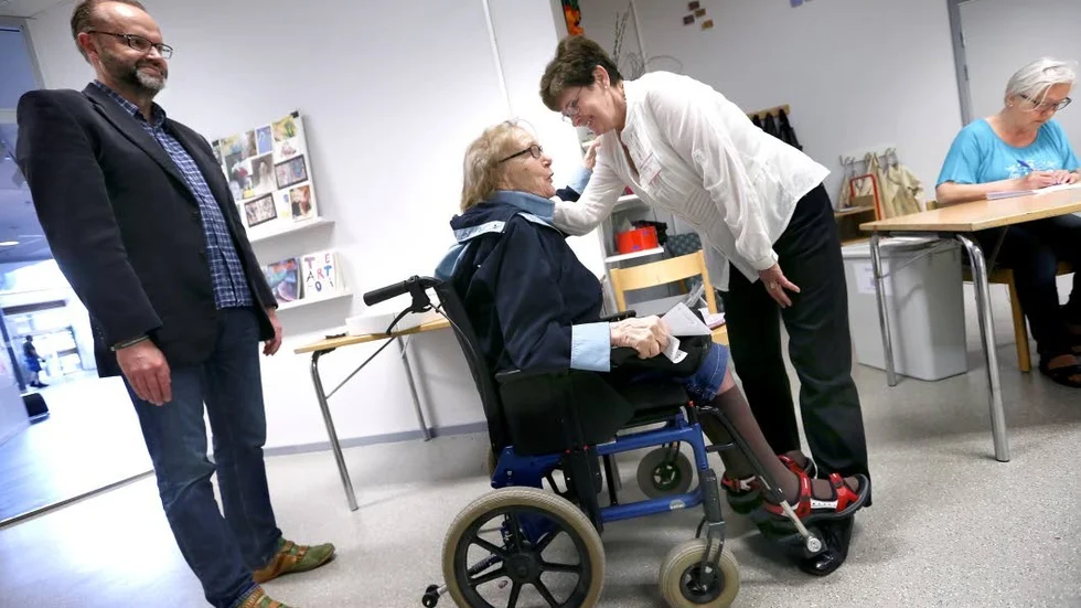 Ute i tid. Sylvia Perä, 90, får hjälp av vännen och C-politikern Stefan Tornberg att förtidsrösta. Tornberg väntar till valdagen men Perä kan inte rösta då. "Röstningen är en hemlighet", säger hon. "Inkastaren" Irene Larsson välkomnar de två.